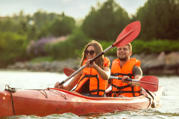 istock Happy couple kayaking on river with sunset on the background 1182412089