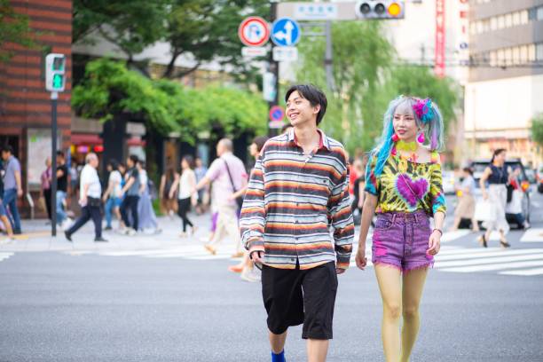 modische junge freunde, die gemeinsam durch die stadt laufen - harajuku district stock-fotos und bilder