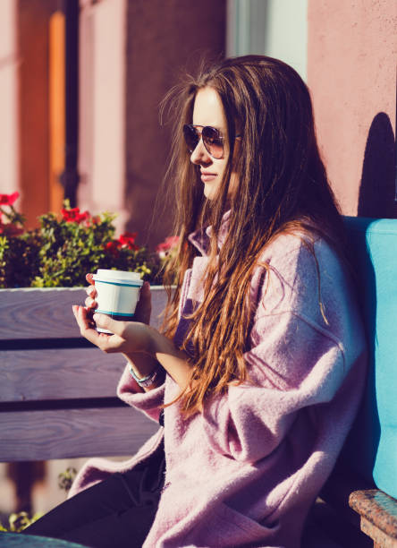 istock woman holding coffee cup 1182413788