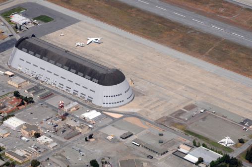 Hanger 1 at Moffett Federal Airfield, Sunnyvale, California, USA. Formerly a naval airstation now operated by NASA Ames. Hanger originally housed Navy dirigible USS Macon and is the largest freestanding structure in the world. NASA research planes on tarmak. The hangar is a Naval Historical Monument. Listed on National Register of Historic Places as Naval Air Station, Sunnyvale, CA, Historic District (Moffett Field) 94000045.