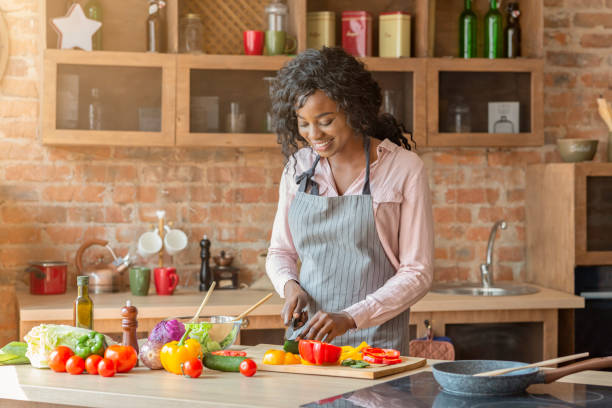 istock Pretty woman making veggies salad at kitchen 1182415111