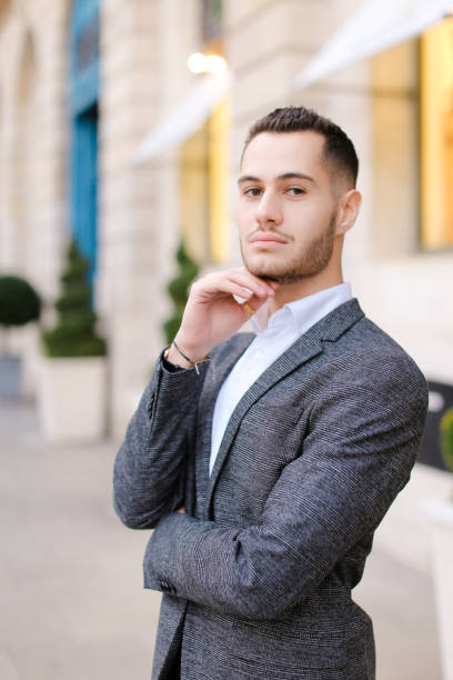 istock Young man wearing grey suit standing near building 1182416002