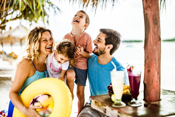 istock Cheerful parents having fun with their kids in a beach cafe. 1182416486