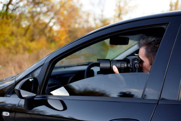 istock Young man with a dslr camera in a car. 1182417509