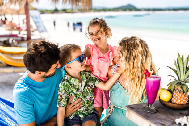 istock Happy parents communicating with their kids in a beach cafe. 1182418267