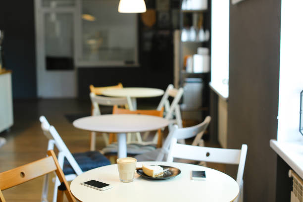 Rattan chairs with mini wooden table against rug cement wall.