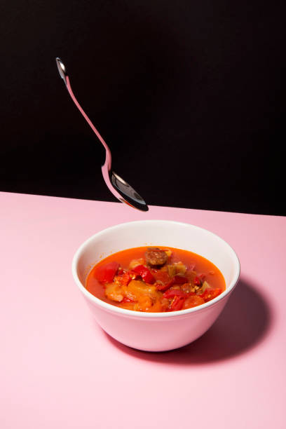 Served goulash soup on pink surface and black backround. stock photo
