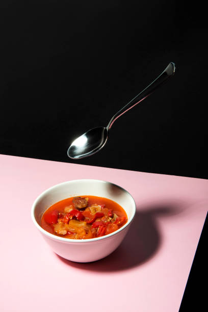 Served goulash soup on pink surface and black backround. stock photo
