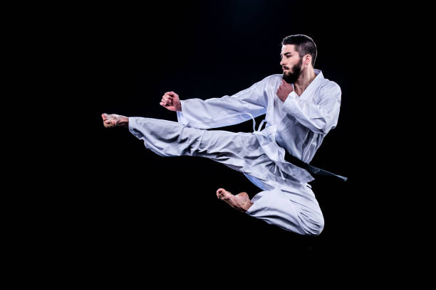 istock Male karate player jumping in air for kick 1182419808