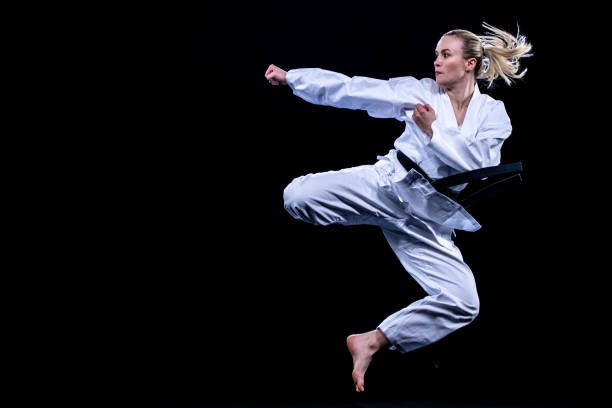 Female karate player jumping in air for kick