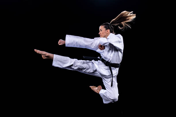 istock Female karate player jumping in air for kick 1182419814