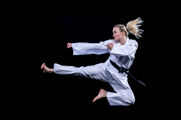 istock Female karate player jumping in air for kick 1182419821