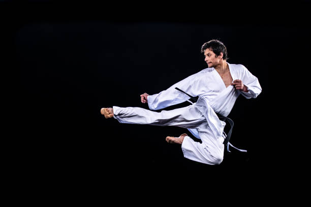 istock Male karate player jumping in air for kick 1182419826