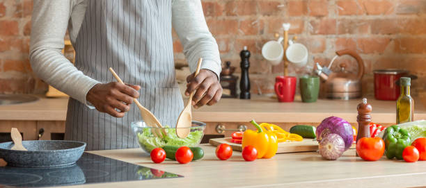 istock Man cooking fresh healthy vegetables salad at kitchen 1182420893