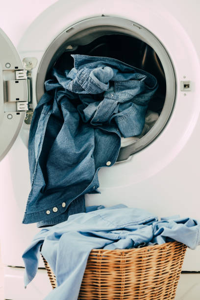 istock Close up washing machine and clothes in basket on white background. Laundry concept. 1182421026
