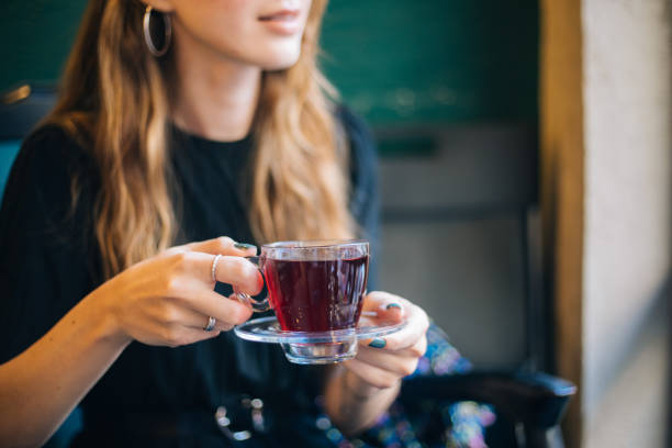 mujer tomando té de invierno en el café - herbal tea fotografías e imágenes de stock