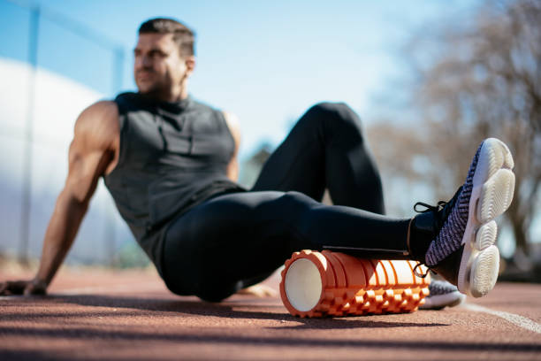 istock Young man stretching himself on a foam roller 1182421310