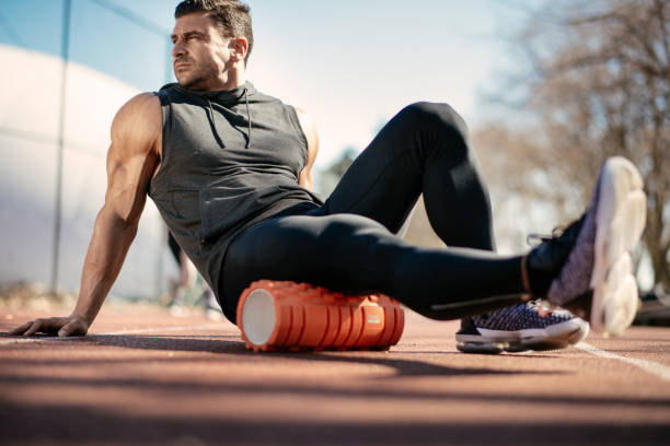 istock Young man stretching himself on a foam roller 1182421634