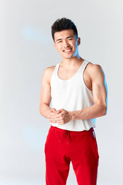 istock Korean gymnast in white undershirt and red sweatpants looking at camera. 1182421788