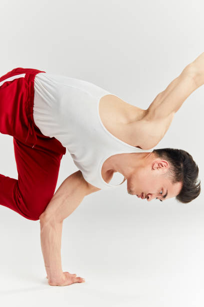 istock Asian male breakdancer dancing on white background, doing shoulder freeze stance 1182422048