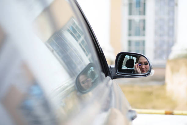 istock Girl doing makeup looking in the rear view mirror 1182423289