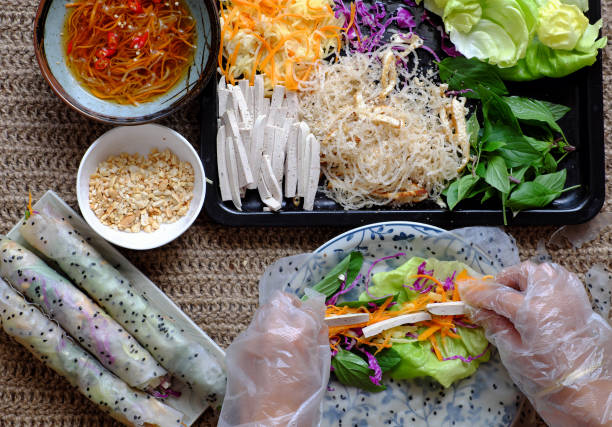 Top view people hand making vegan rice paper rolls
