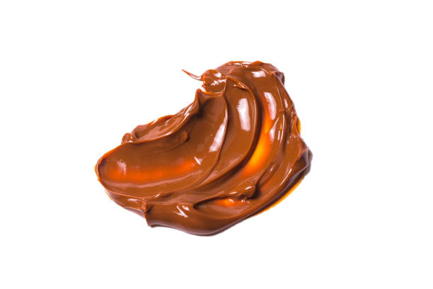 istock Melted tasty caramel splashes isolated on white background. 1182423414