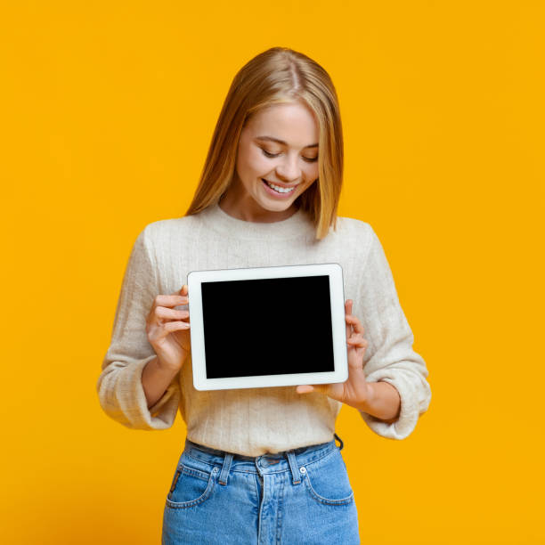 istock Girl holding and looking at digital tablet with blank screen 1182423445