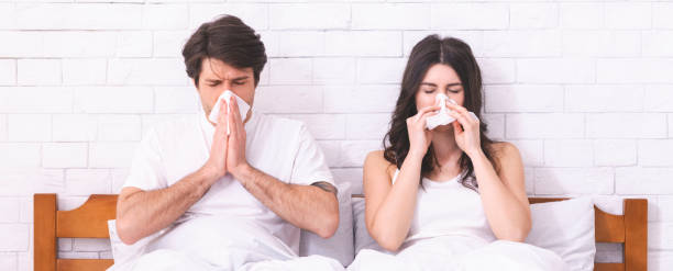 homem e mulher millennial que sofrem do vírus sazonal - cold and flu flu virus bed couple - fotografias e filmes do acervo