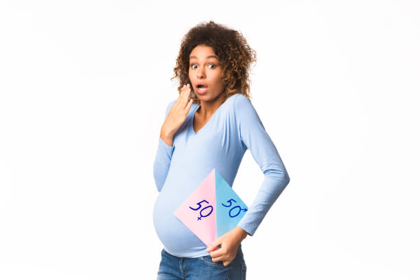 sorpresa donna incinta in possesso di carta con domande ragazzo o ragazza - african descent question mark holding asking foto e immagini stock