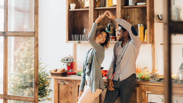 istock Young african-american couple dancing in kitchen, copy space 1182426401