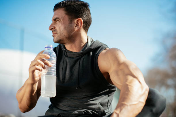 istock Young athlete drinking water after exercising 1182426594