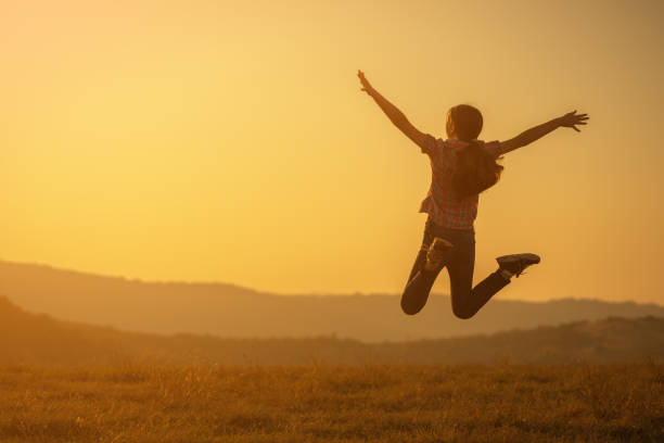 istock Happy child jumping in nature in sunset. 1182426808