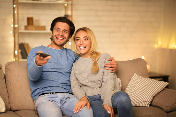 istock Happy spouses watching TV on sofa in the evening 1182427427