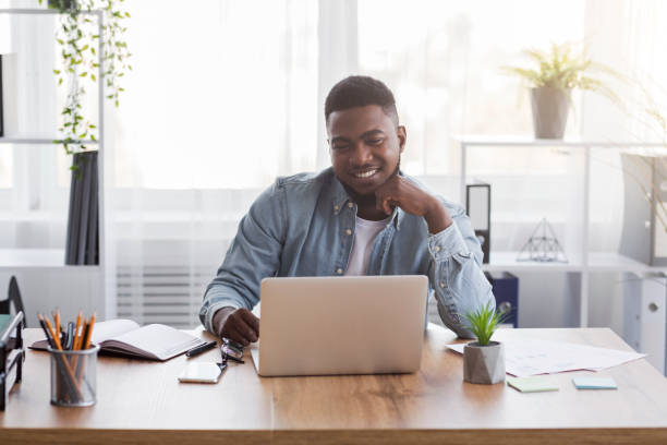 istock Successful project. Smiling businessman looking at laptop screen at workplace. 1182427596
