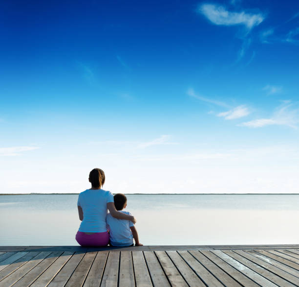 istock Mother with her son enjoying lake view 1182428053