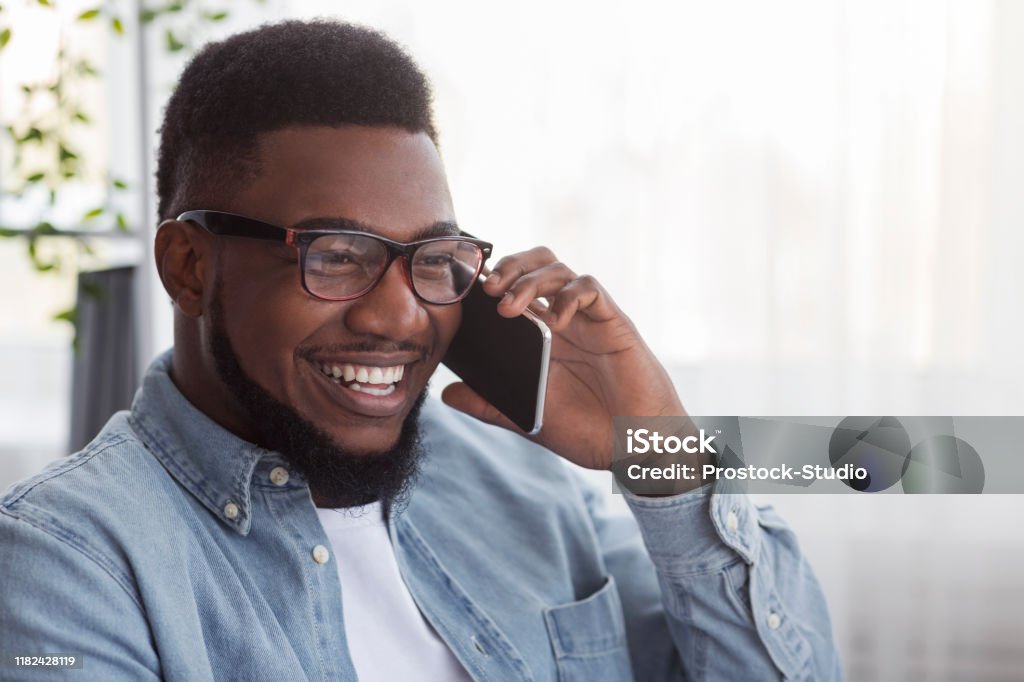kampagne som resultat Karu Joyful Black Guy In Glasses Talking On Mobile Phone Stock Photo - Download  Image Now - iStock
