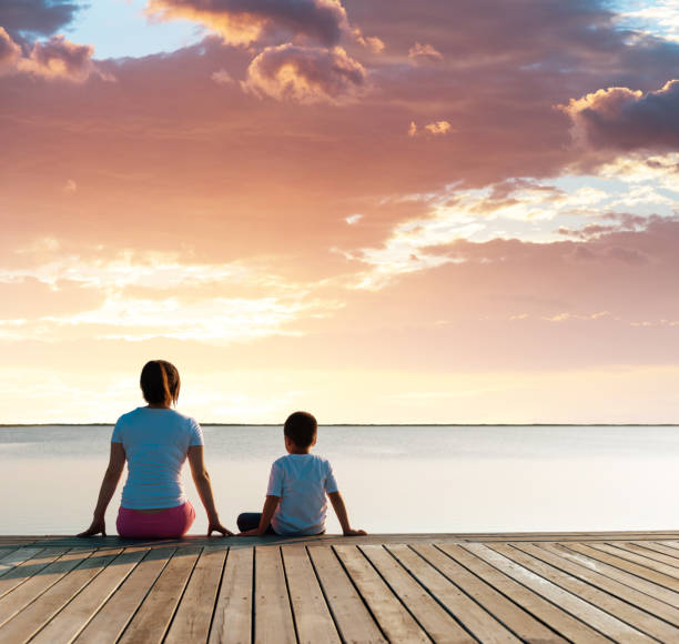 istock Mother with her son enjoying lake view at sunset 1182428278
