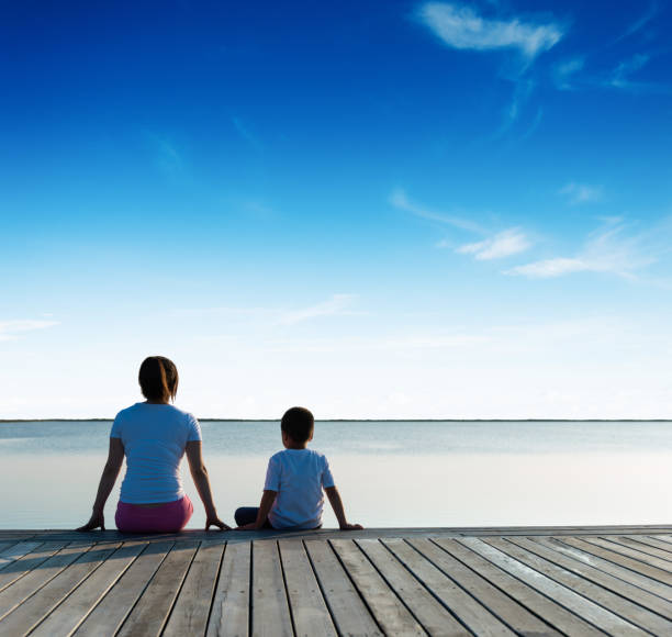 istock Mother with her son enjoying lake view 1182428319