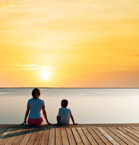 istock Mother with her son enjoying lake view at sunset 1182429041