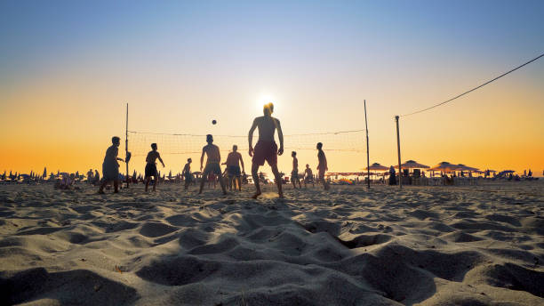 Silhouette Volleyball players play on beach at sunset Durres, Albania - 26 Aug, 2018: Silhouette Volleyball players play on beach at sunset volleying stock pictures, royalty-free photos & images