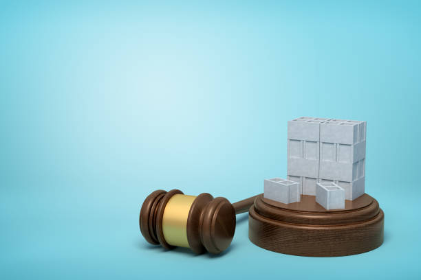 istock 3d rendering of stack of grey hollow bricks on sounding block with judge gavel lying beside on light-blue background. 1182432112