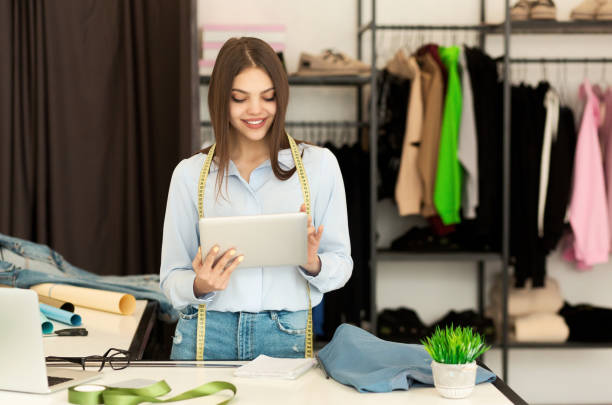 istock Tailor Girl Using Digital Tablet Sketching In Clothing Design Workshop 1182432117