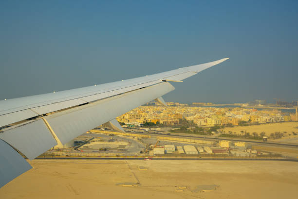 istock airplane wing on desert city background 1182434300