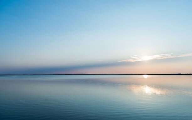 reflejos de la puesta de sol con paisaje nublado en el agua del lago - tranquil scene fotos fotografías e imágenes de stock