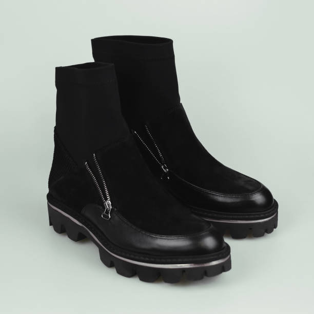 istock Female black boots on gray background 1182434616