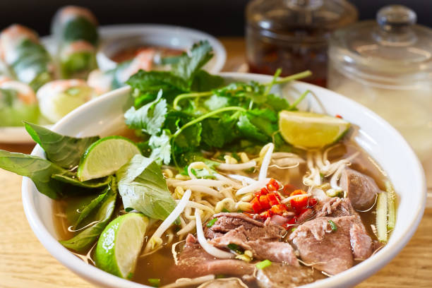istock Vietnamese raw beef rice noodle soup with lime and vegetables 1182434889