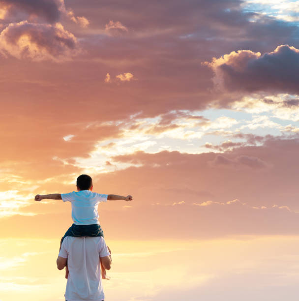istock Father carrying his son on shoulders 1182435199
