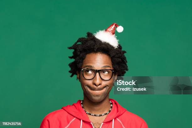 Funny Christmas Portrait Of Pensive Young Man Wearing In Red Blouse Stock Photo - Download Image Now