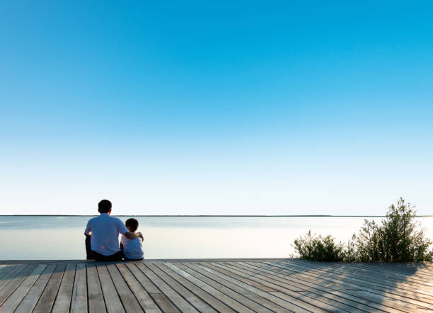 istock Father with his son enjoying lake view 1182435857